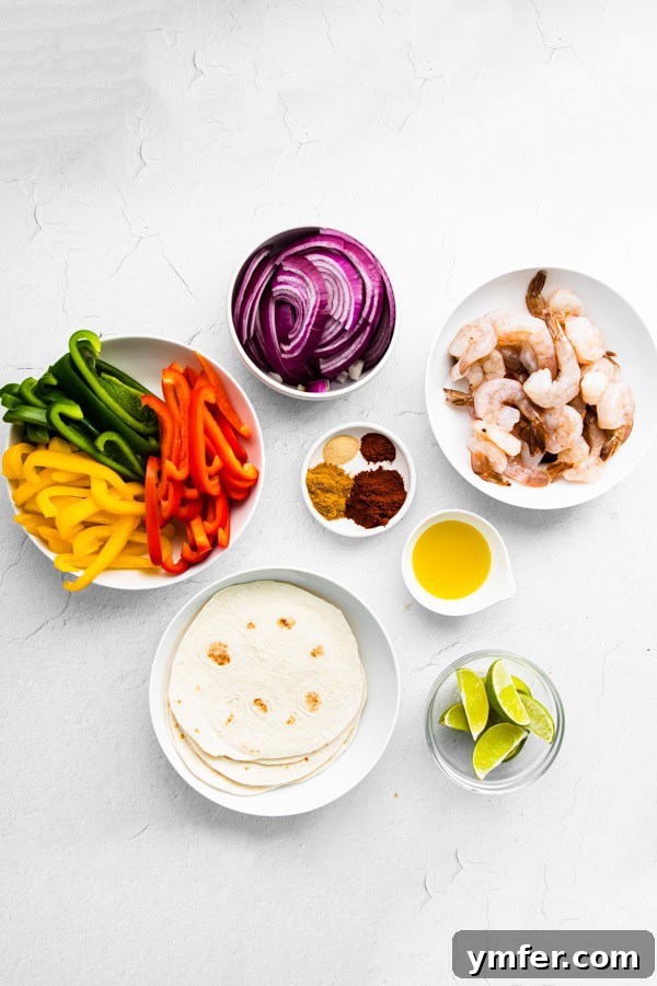 One-Pan Shrimp Fajitas 3 Fresh ingredients for Sheet Pan Shrimp Fajitas, including bell peppers, red onion, raw shrimp, and a bowl of spices, laid out on a table.
