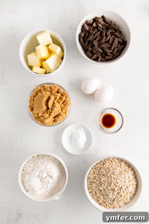 Ultimate Chocolate Chunk Oatmeal Bars 3 All the essential ingredients for Chocolate Chunk Oatmeal Cookie Bars laid out on a rustic wooden table.