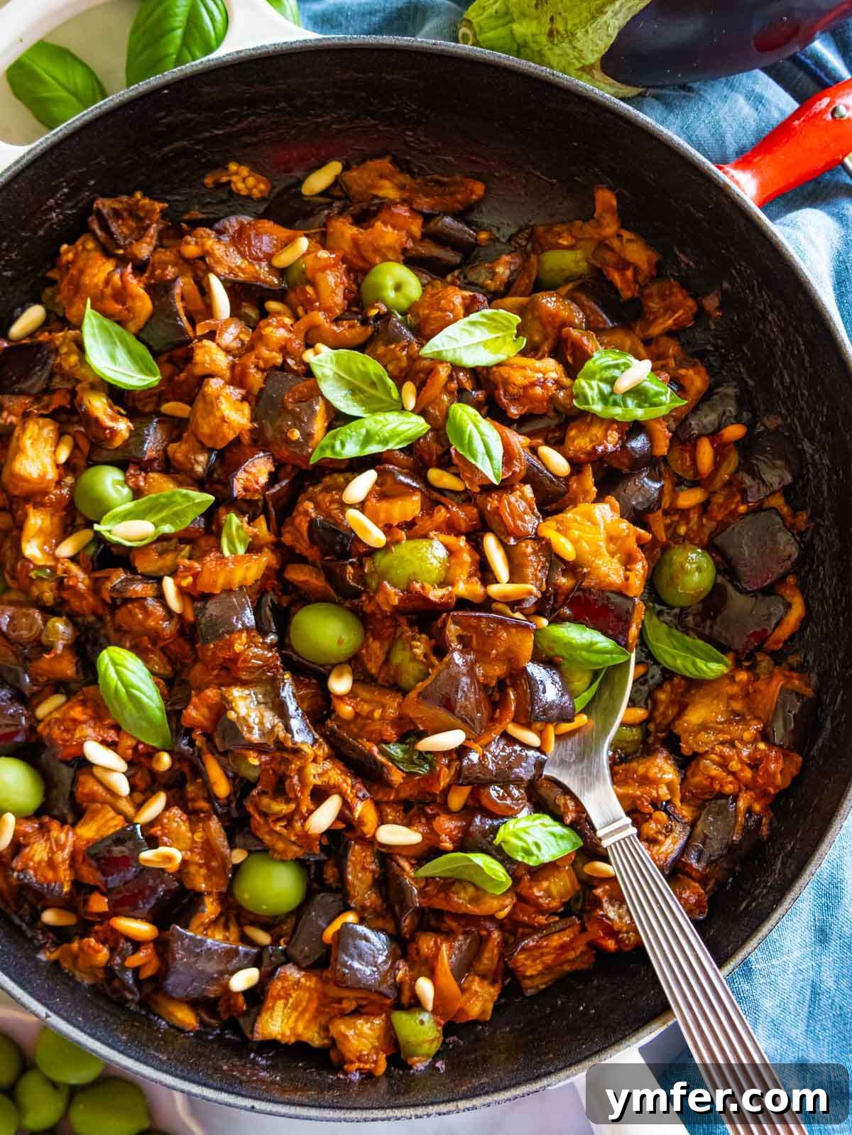 Wholesome Eggplant Caponata 2 Top-down view of authentic Sicilian caponata served in cast iron skillet with basil.