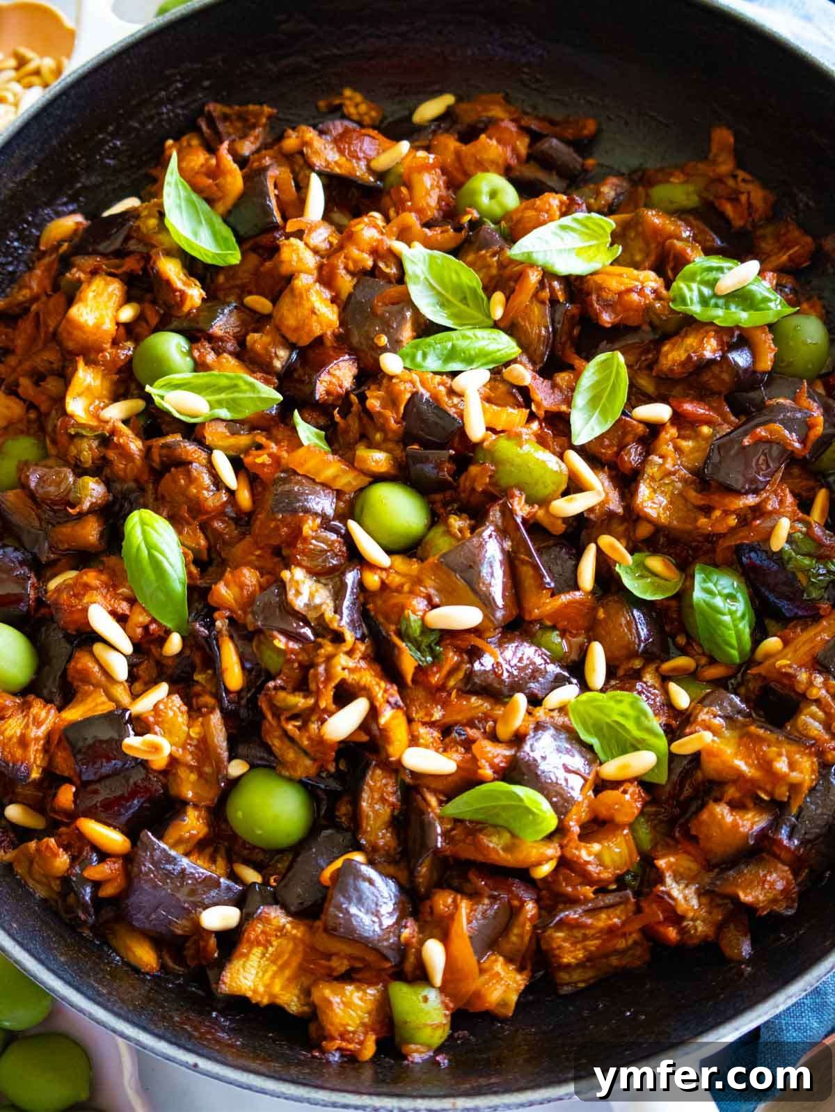 Wholesome Eggplant Caponata 3 Close-up of authentic Sicilian caponata recipe with roasted eggplant, olives, pine nuts, and fresh basil in a rich sweet and sour sauce.
