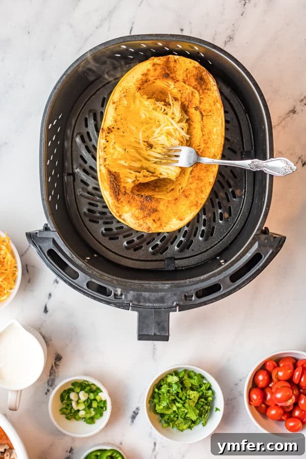Zesty Southwestern Air Fryer Spaghetti Squash 4 Spaghetti squash halves being cooked to perfection in an air fryer.