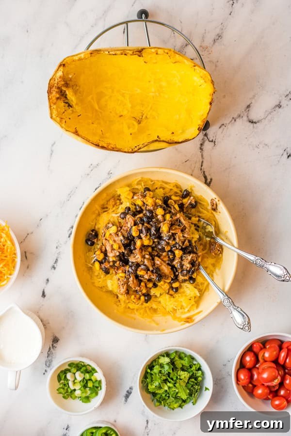 Zesty Southwestern Air Fryer Spaghetti Squash 5 Cooked spaghetti squash mixed with a savory chicken and bean filling, ready to be stuffed.