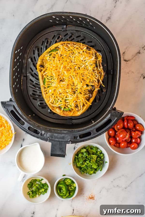 Zesty Southwestern Air Fryer Spaghetti Squash 6 Air Fryer Southwest Spaghetti Squash generously topped with melted cheese, cooking in the air fryer.