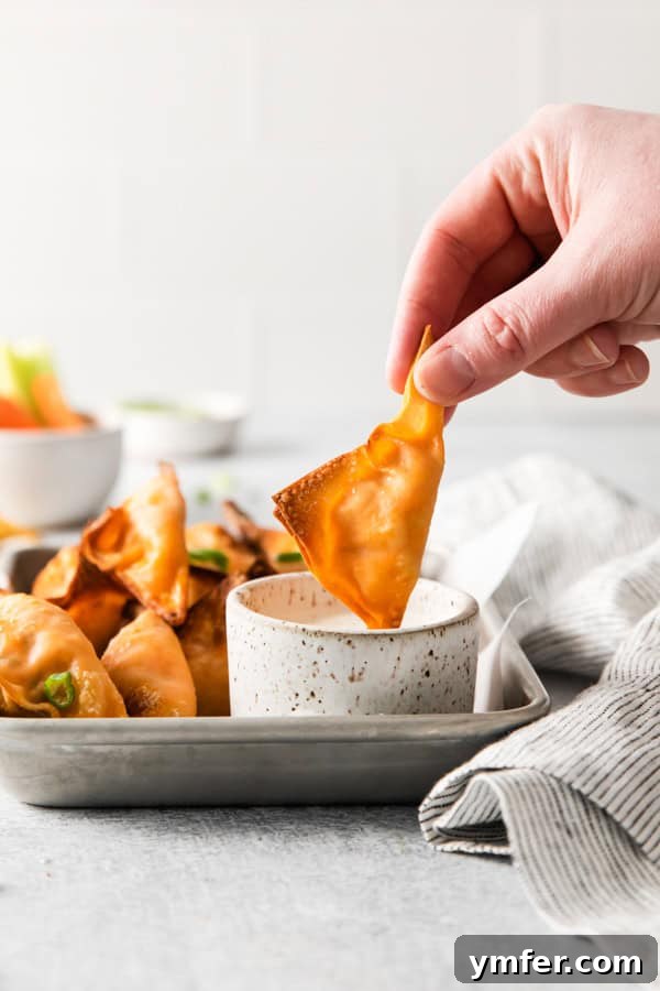 Crispy Air Fried Buffalo Wonton Poppers 9 Air Fryer Buffalo Chicken Wontons being dipped into blue cheese dressing.