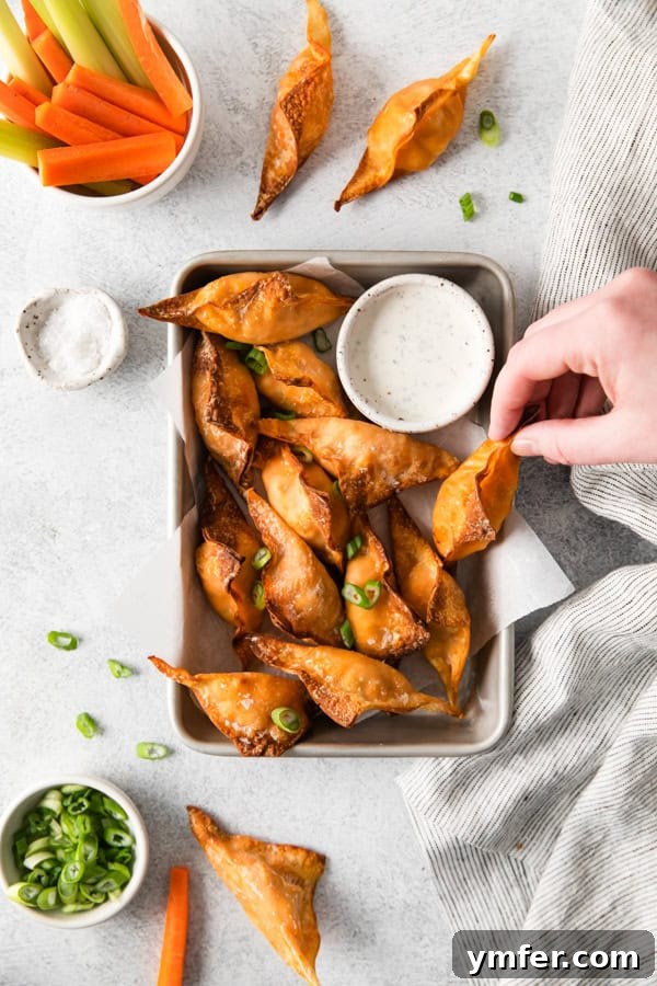 Crispy Air Fried Buffalo Wonton Poppers 7 Air Fryer Buffalo Chicken Wontons being picked up.