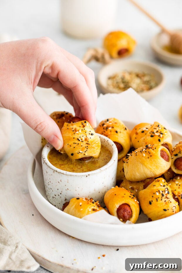 Crunchy Everything Piggy Rolls 9 Dipping a Everything Bagel Pigs in a Blanket into homemade sauce.