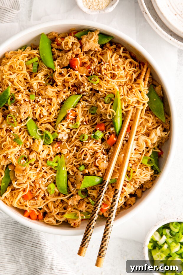 Umami Chicken Ramen Stir Fry 8 Ground Chicken Ramen Stir Fry served with sesame seeds and chopsticks.