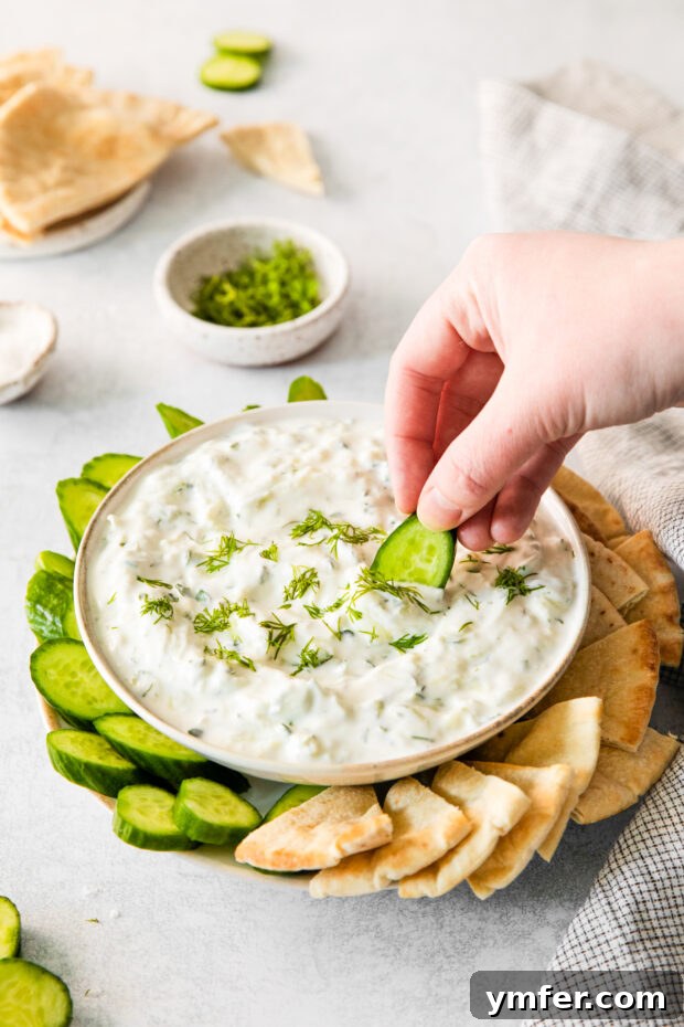 Refreshing Cucumber Yogurt Dip 9 A bowl of fresh Tzatziki sauce served alongside an array of colorful fresh vegetables, perfect for dipping.