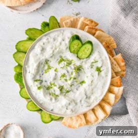 A close-up image of a bowl of Tzatziki sauce, garnished with fresh herbs, ready to be served.