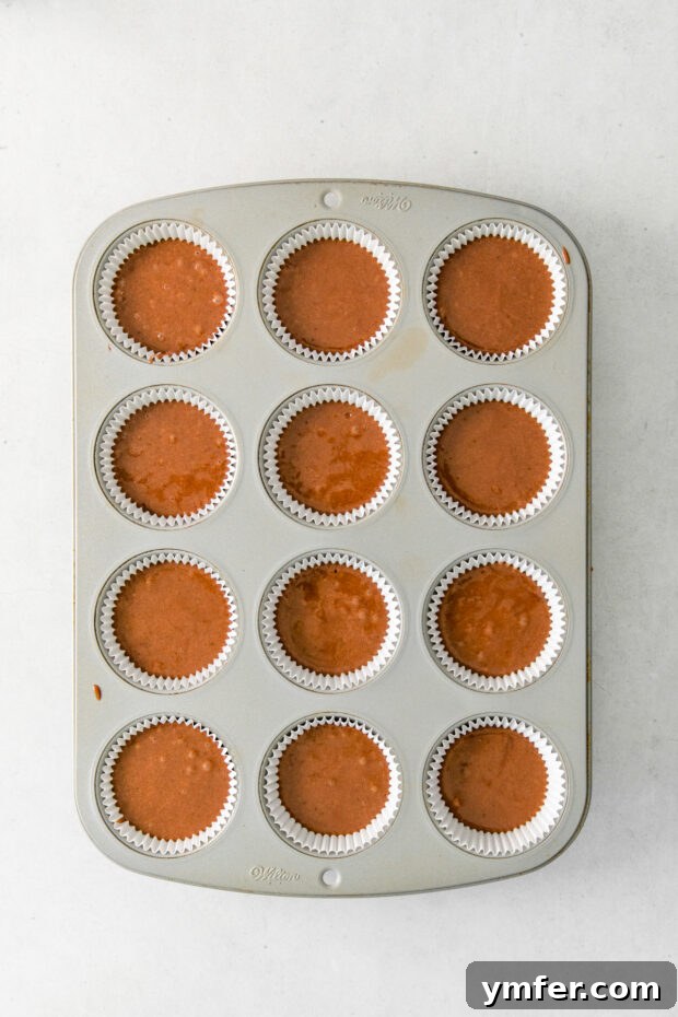 Velvet Stout Chocolate Cupcakes 8 Dark chocolate cupcake batter expertly portioned into a muffin pan, ready for baking.