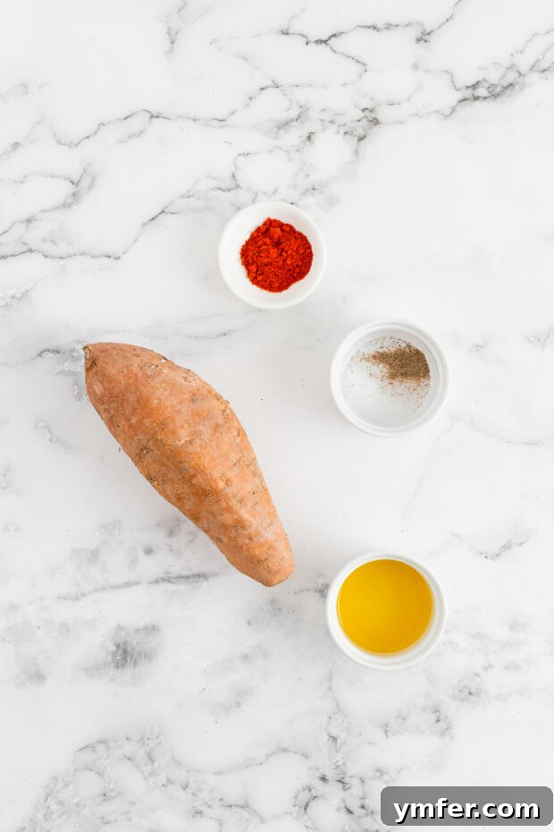 Gourmet Sweet Potato Fries 3 Fresh sweet potato, a bowl of spices, and a bottle of olive oil arranged on a rustic wooden table, ready for cooking.