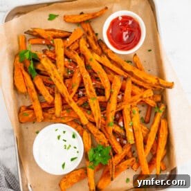 A close-up of crispy sweet potato fries on a sheet pan, ready to serve.