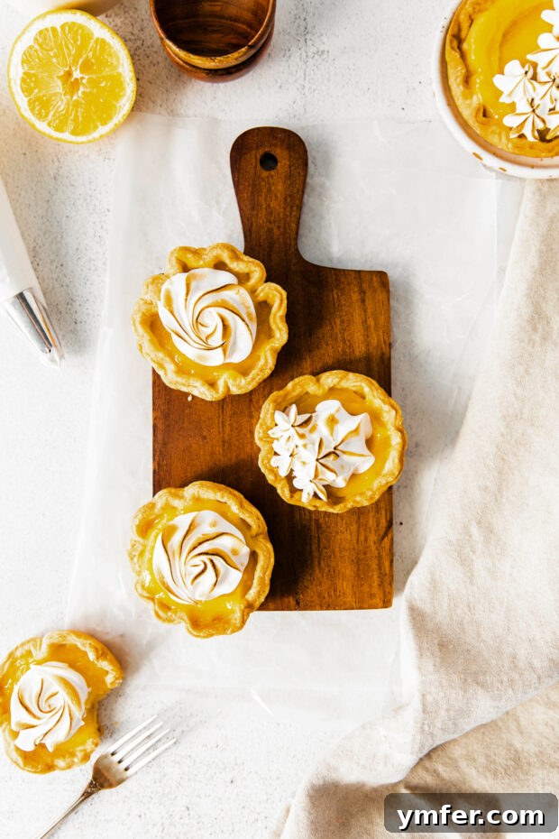 Cloud-Kissed Lemon Tartlets 2 A stunning display of golden mini lemon meringue tarts on a rustic cutting board, ready to be enjoyed.