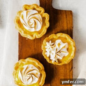 Cloud-Kissed Lemon Tartlets 15 A beautifully arranged mini lemon meringue tart, showcasing its golden crust, zesty filling, and fluffy toasted meringue.