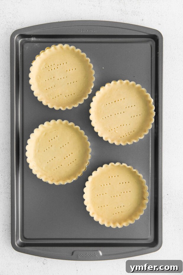 Mini Boston Cream Delights 4 Uncooked refrigerated pie crusts pressed into mini tart pans, ready for baking.