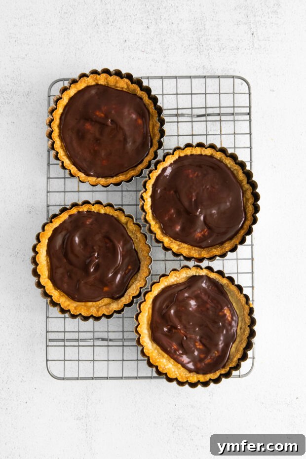 Mini Boston Cream Delights 6 Baked pie crusts spread with a layer of chocolate ganache at the bottom.