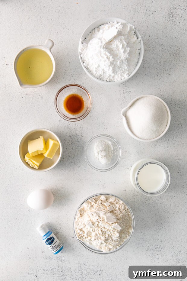 Robin's Egg Blue Baked Donuts 3 Ingredients for Robin's Egg Baked Donuts laid out on a table, including flour, sugar, milk, and eggs.