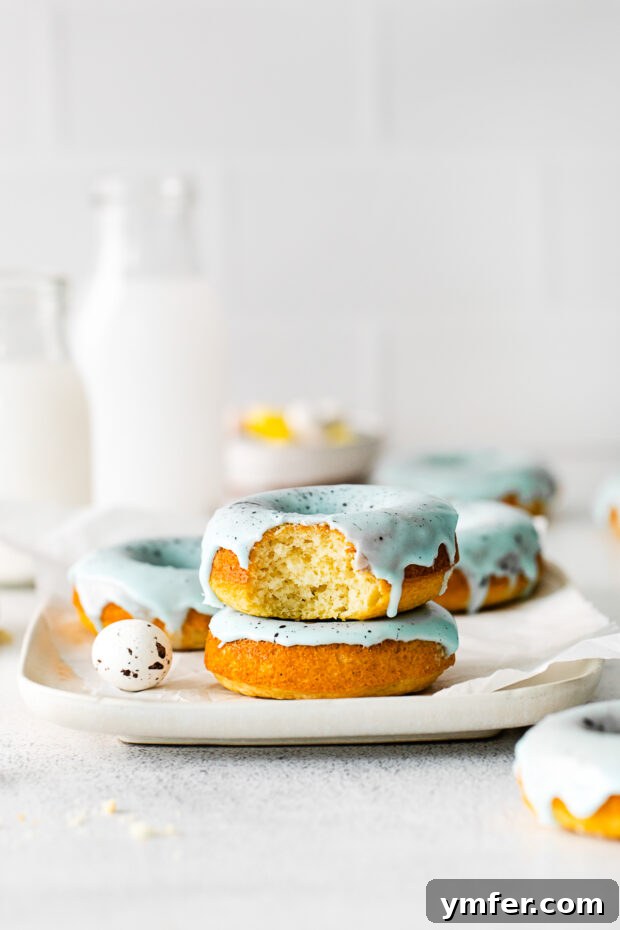 Robin's Egg Blue Baked Donuts 7 A baked donut with a bite taken out of it, revealing the fluffy vanilla interior and the blue speckled glaze.