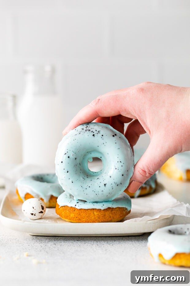 Robin's Egg Blue Baked Donuts 9 A hand holding a Robin's Egg Baked Donut, showing its inviting texture and glaze.