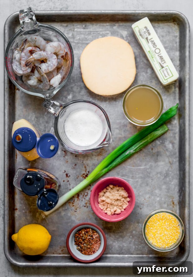Cajun Honey Butter Shrimp with Creamy Grits 3 Various fresh ingredients laid out on a sheet pan, ready to make Cajun Honey Butter Shrimp and Grits.