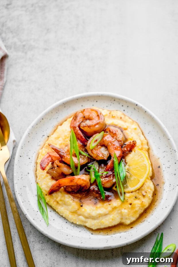 Cajun Honey Butter Shrimp with Creamy Grits 7 A bowl of Cajun Honey Butter Shrimp and Grits, with extra sauce drizzled over the top.