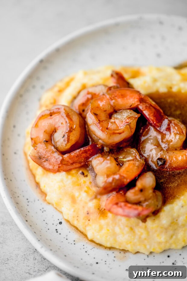 Cajun Honey Butter Shrimp with Creamy Grits 8 Cajun Honey Butter Shrimp and Grits served in a rustic bowl.