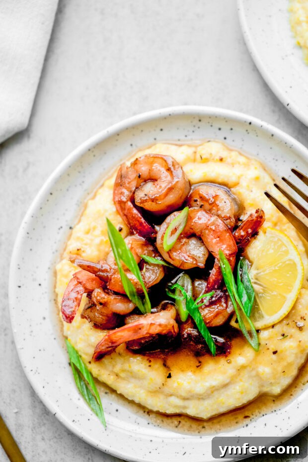 Cajun Honey Butter Shrimp with Creamy Grits 9 Cajun Honey Butter Shrimp and Grits garnished with freshly chopped green onions.