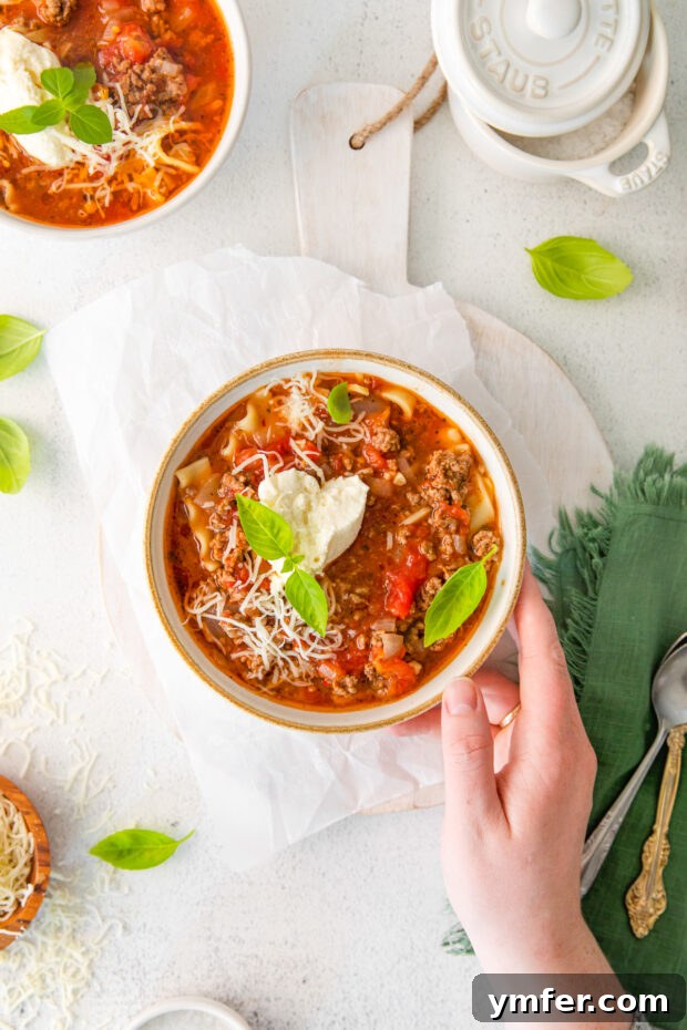 Easy Instant Pot Lasagna Soup 11 A bowl of Instant Pot Lasagna Soup held by a hand, ready to be enjoyed.