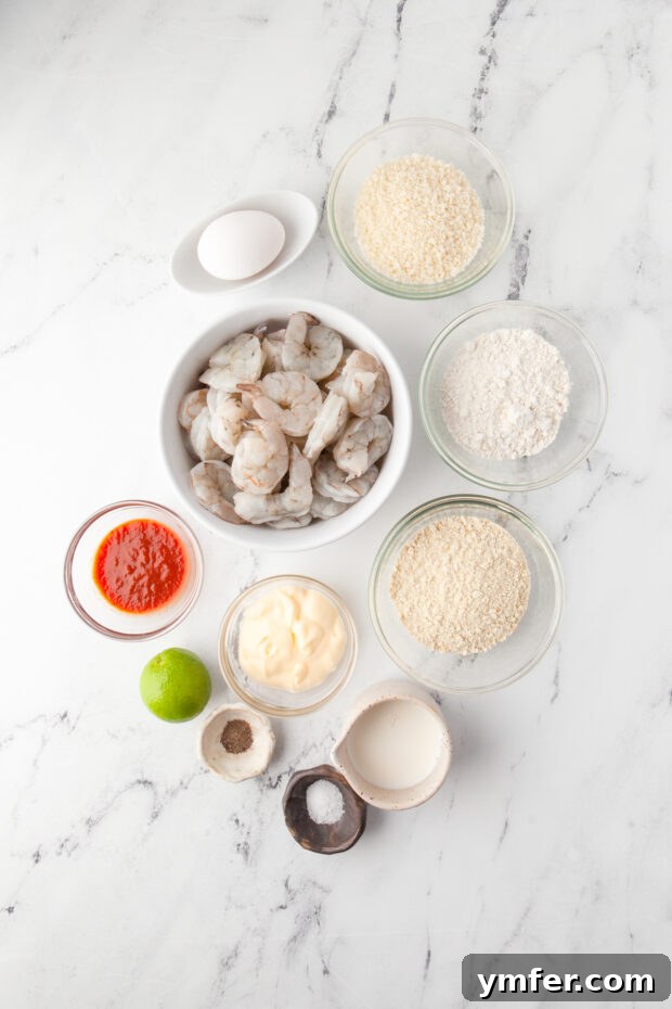 Golden Crispy Air Fryer Shrimp 3 Crispy Air Fryer Shrimp ingredients laid out on a rustic wooden table, including fresh shrimp, limes, eggs, flour, and two types of breadcrumbs.