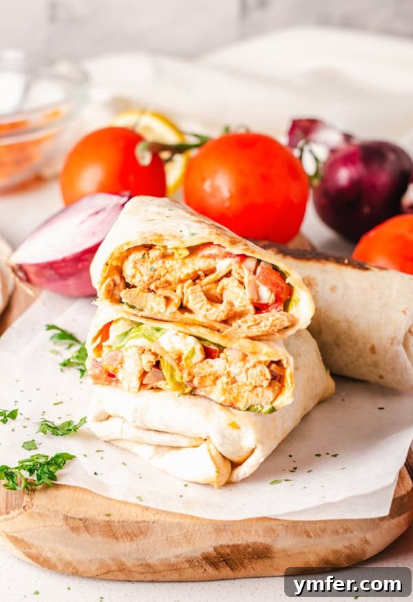 Zesty Buffalo Chicken Wrap 2 Buffalo Chicken Wrap cut in half, showcasing layers of chicken, lettuce, tomato, and dressing.