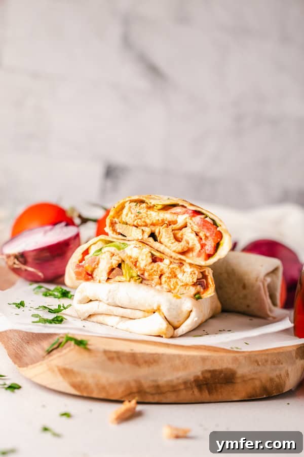 Zesty Buffalo Chicken Wrap 5 A Buffalo Chicken Wrap cut in half, elegantly presented on a serving board with a side of blue cheese dressing.