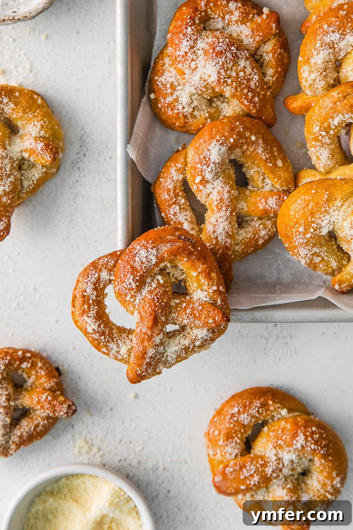 Freshly baked garlic parmesan soft pretzels arranged on a rustic wooden tray, ready to be served.