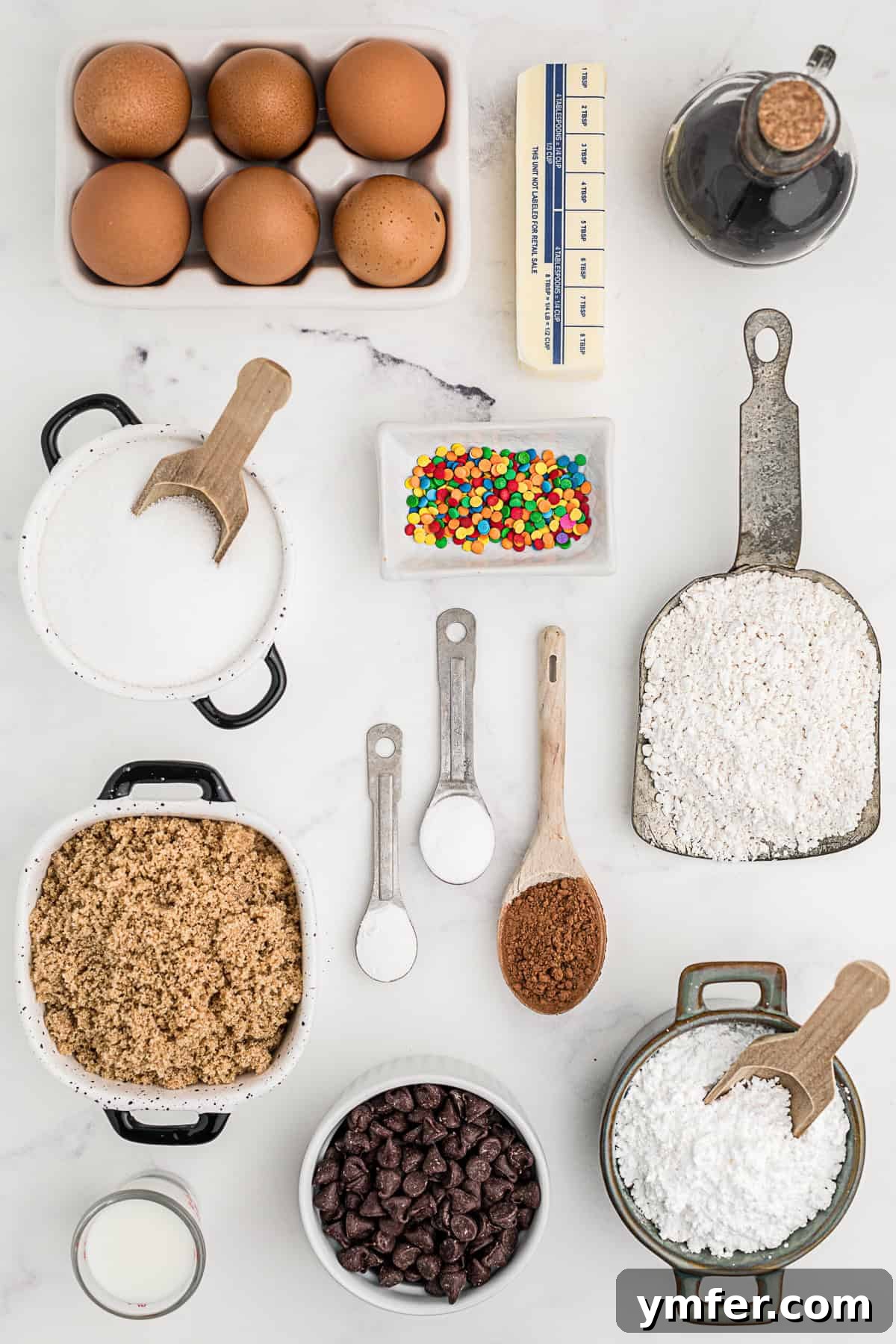 Ultimate Chocolate Chip Cookie Cake 3 A flat lay photograph showcasing all the essential ingredients needed to bake a delicious Chocolate Chip Cookie Cake, neatly arranged on a counter.