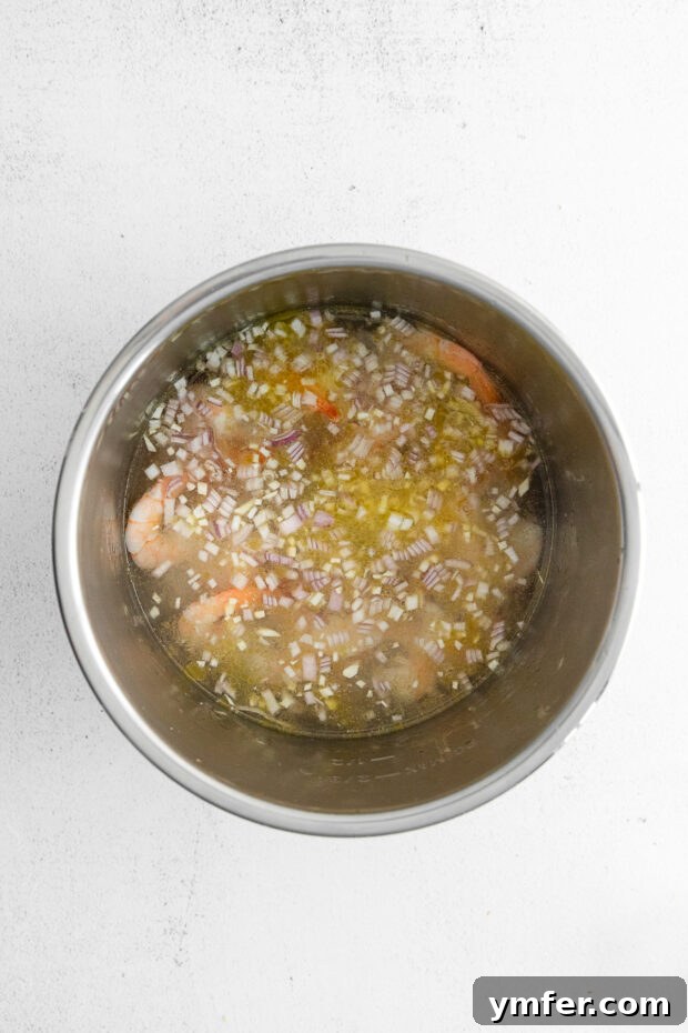 Effortless Instant Pot Shrimp Scampi 5 Shrimp and shallots with water in an Instant Pot.