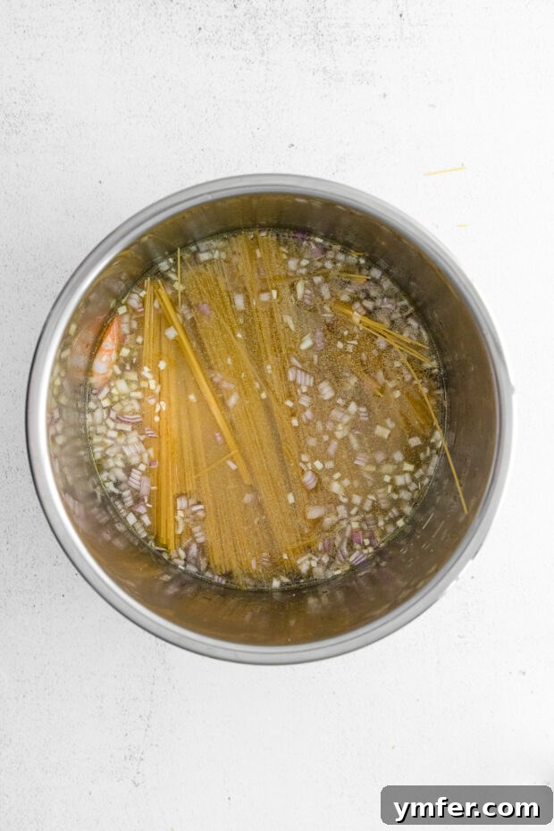 Effortless Instant Pot Shrimp Scampi 6 Shrimp, water, and pasta in an Instant Pot.