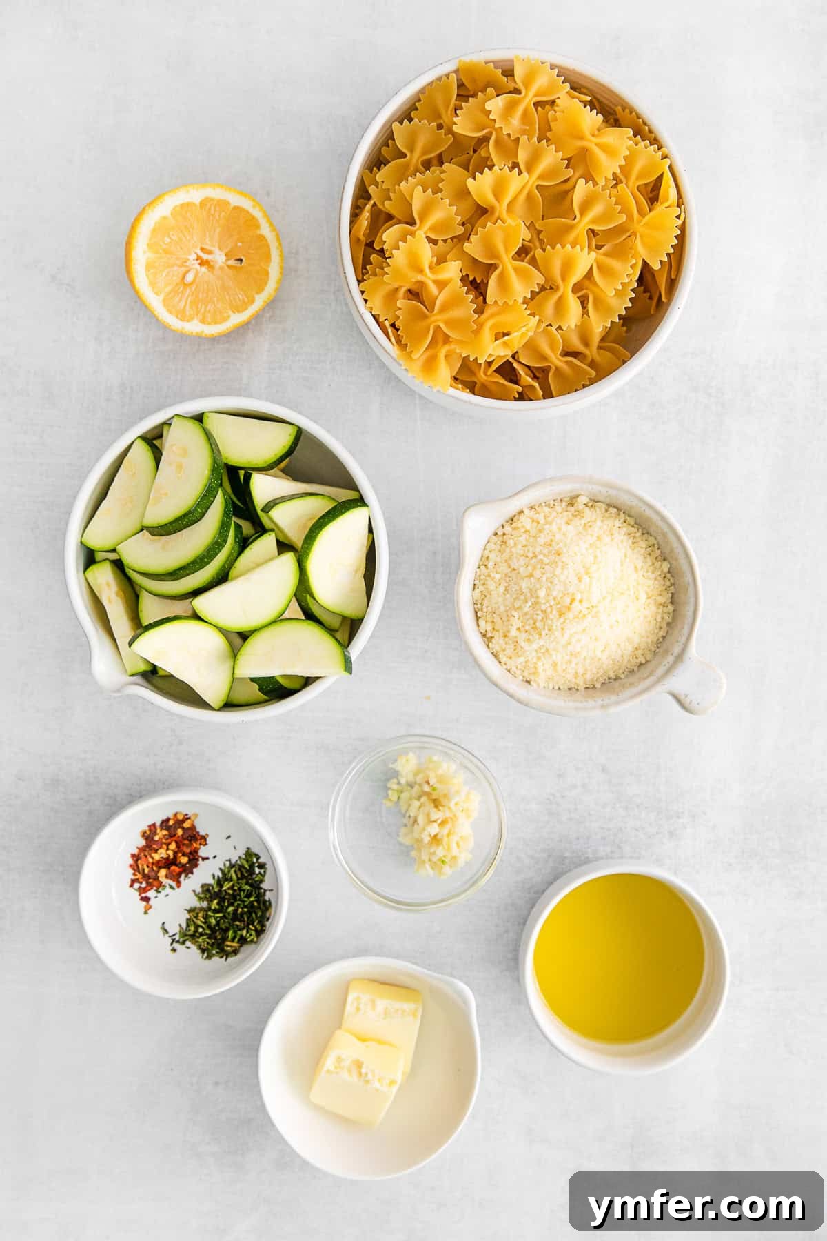 Bright Lemon Zucchini Pasta 3 A selection of fresh ingredients including zucchini, lemons, garlic, and pasta laid out on a table, ready for making Lemon Zucchini Pasta.