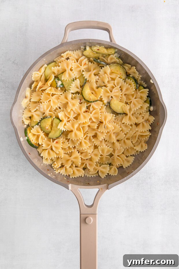 Bright Lemon Zucchini Pasta 6 Lemon Zucchini Pasta tossed together in a skillet, ready to be served.