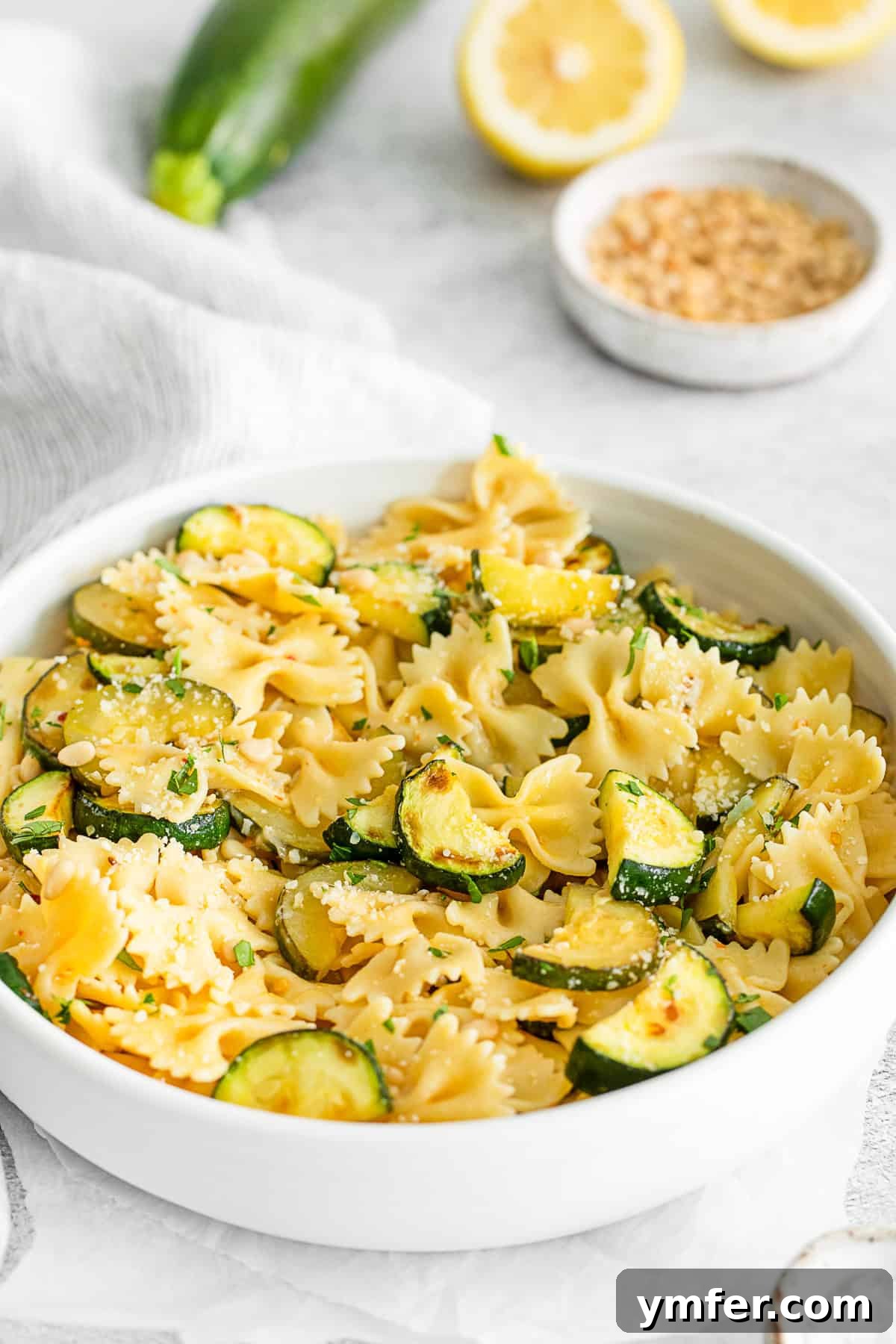Bright Lemon Zucchini Pasta 7 A serving of Lemon Zucchini Pasta generously topped with grated Parmesan cheese.