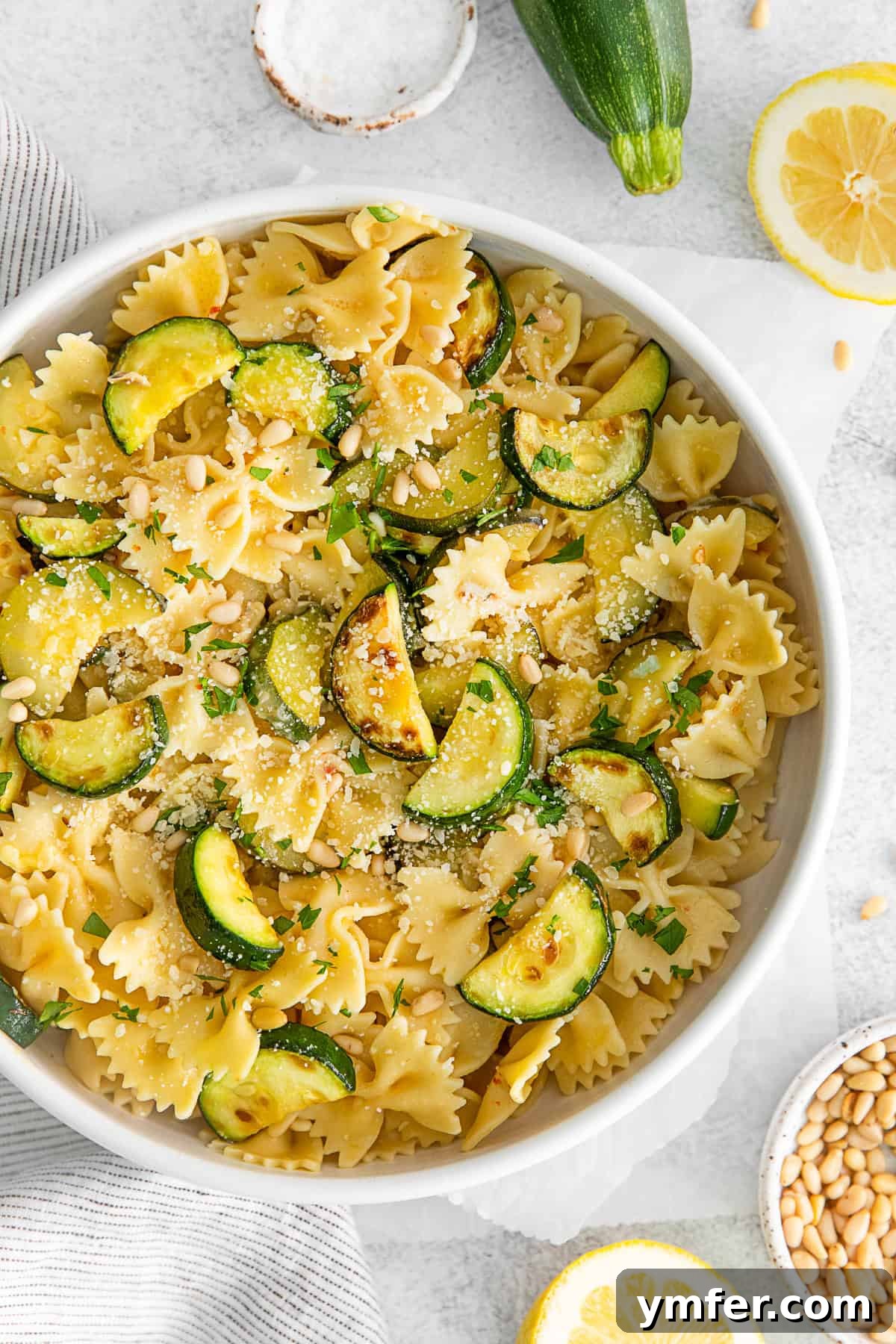 Bright Lemon Zucchini Pasta 8 Lemon Zucchini Pasta in a bowl, garnished with fresh parsley and toasted pine nuts.