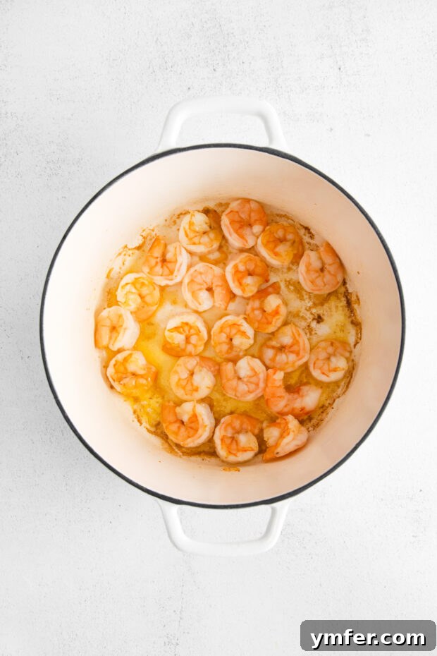 Golden Harvest Shrimp and Corn Chowder 4 Perfectly cooked shrimp in a large pot, ready to be removed.