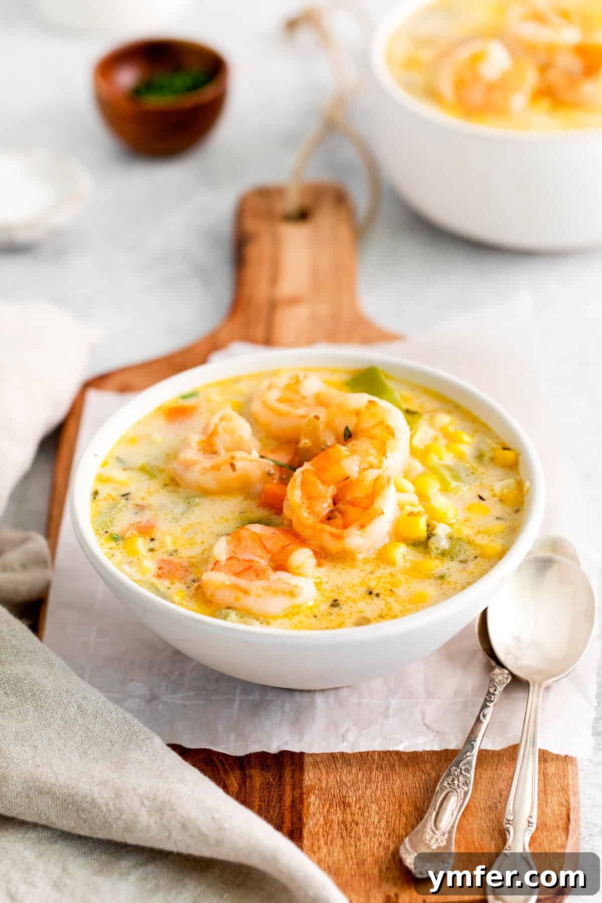 Golden Harvest Shrimp and Corn Chowder 7 A bowl of Shrimp Corn Chowder, beautifully topped with extra cooked shrimp and fresh greens.