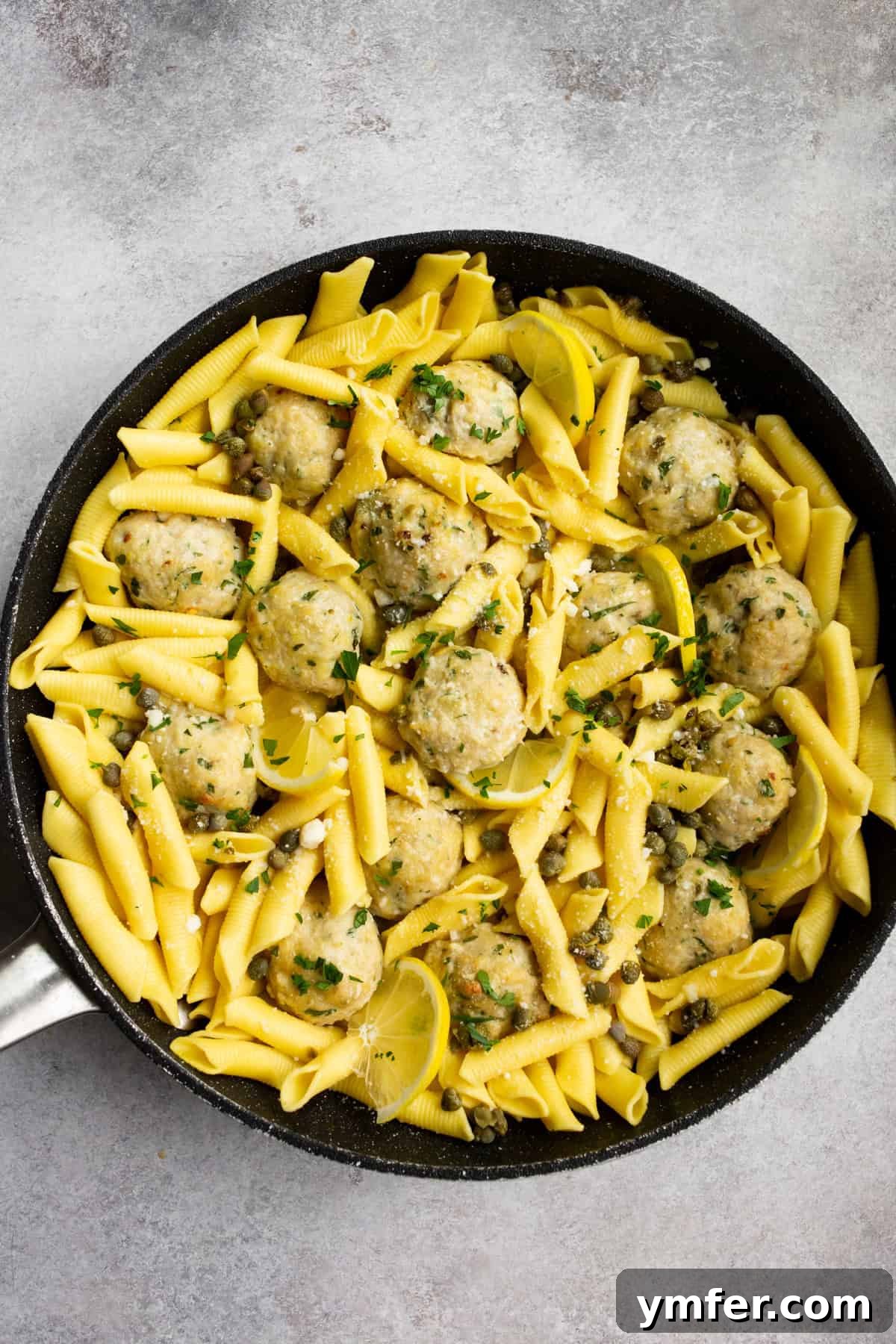Tangy Lemon Caper Chicken Meatballs 2 Delicious chicken piccata meatballs served with pasta and lemon slices.