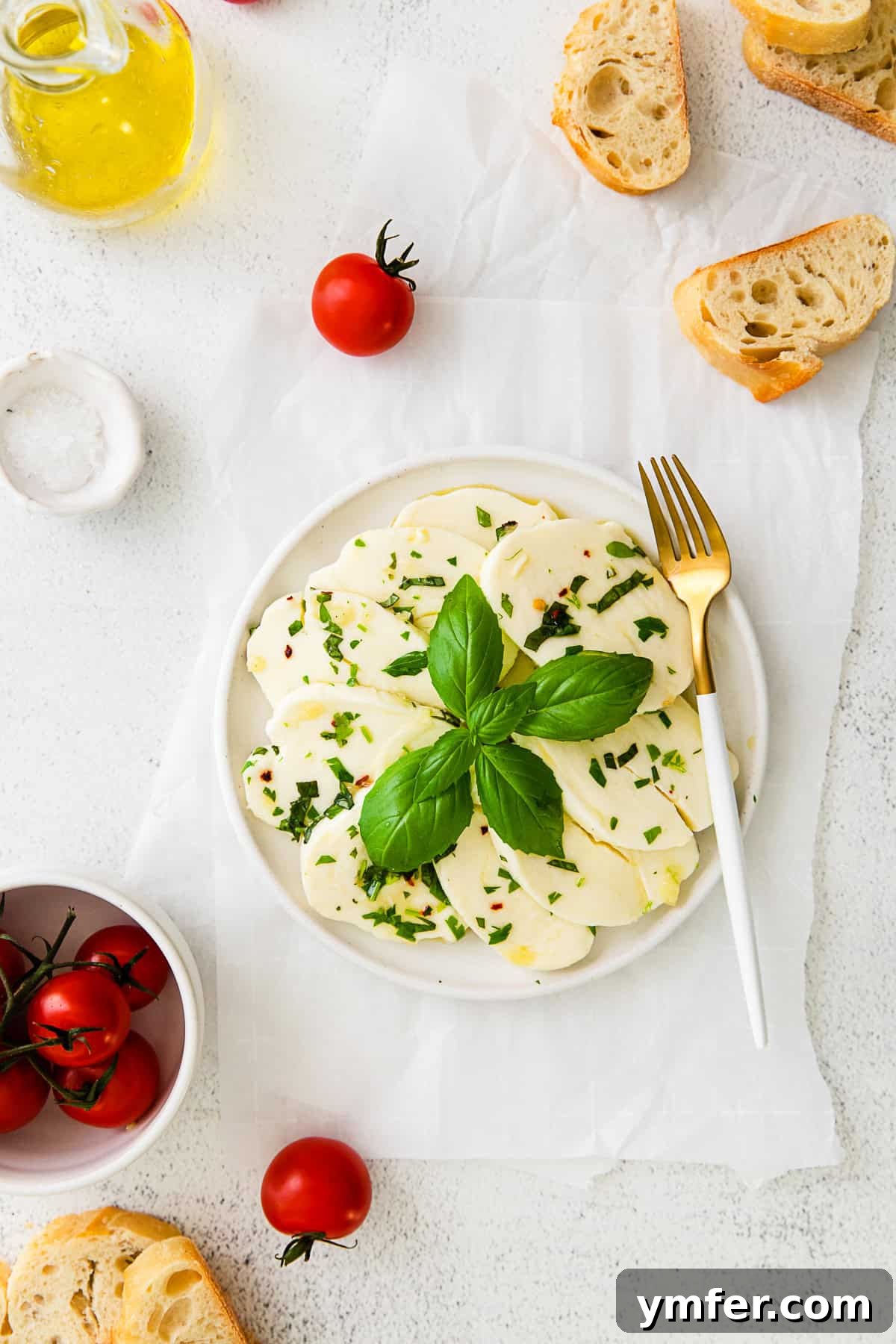 Flavorful Mozzarella Delights 8 Marinated Mozzarella on a small white plate with a fork.