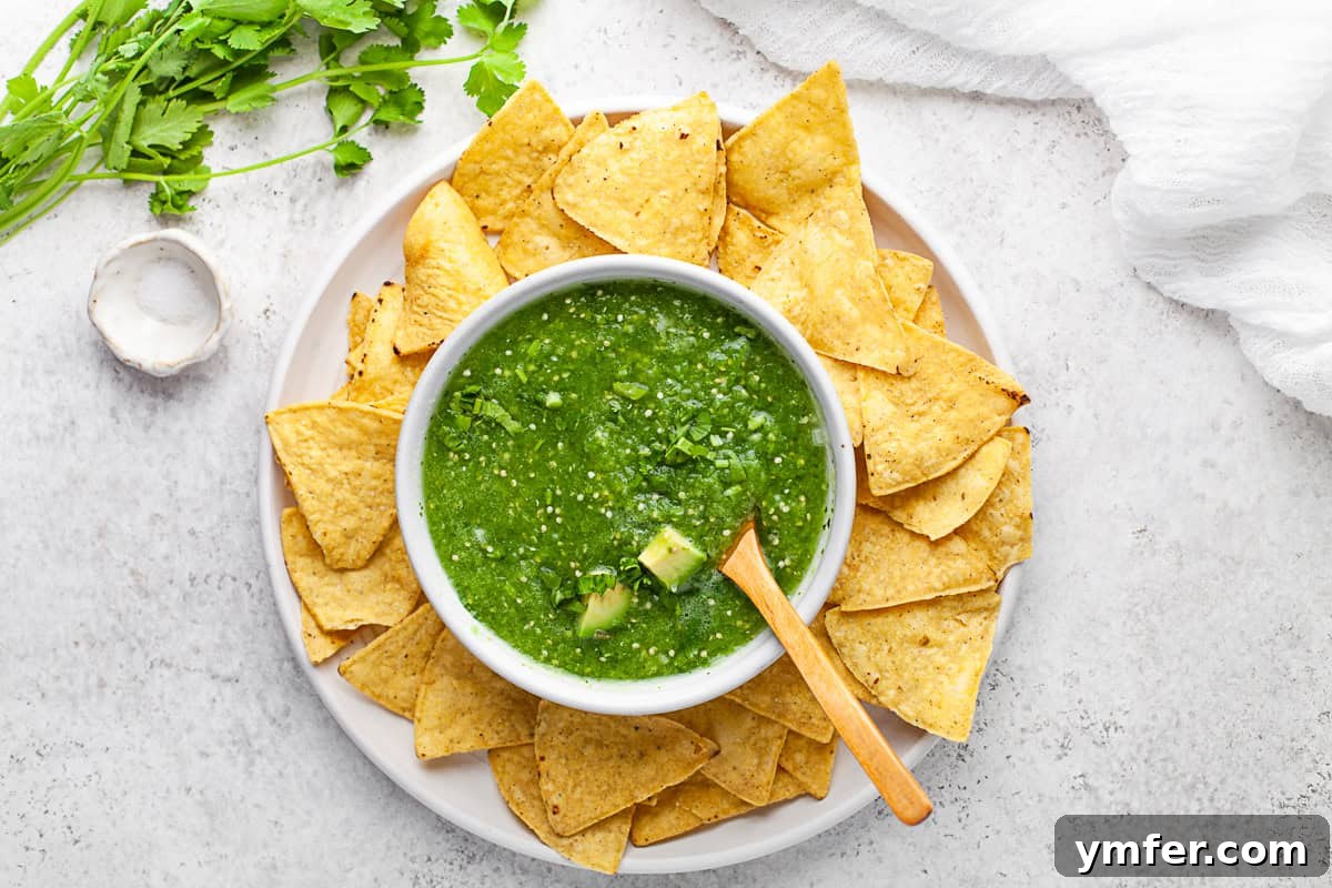 Vibrant Homemade Salsa Verde 8 Homemade Salsa Verde in a bowl with chips and extra cilantro on top.