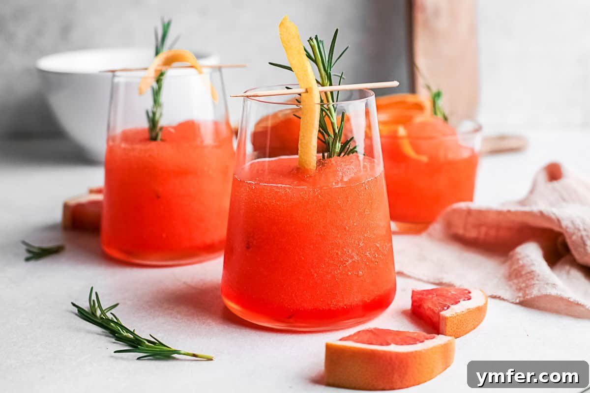 Slushy Aperol Bliss 8 Frozen Aperol Spritz sitting on a table with sliced fresh citrus.