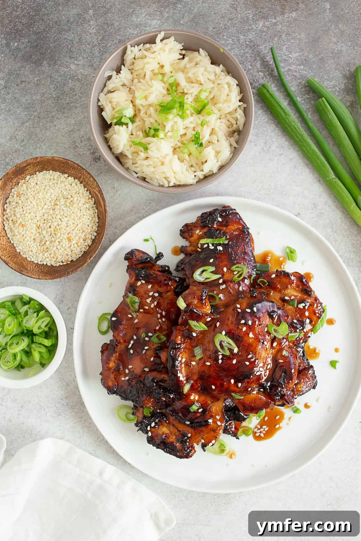 Grilled Teriyaki Chicken pieces on a long serving platter, garnished with green onions.