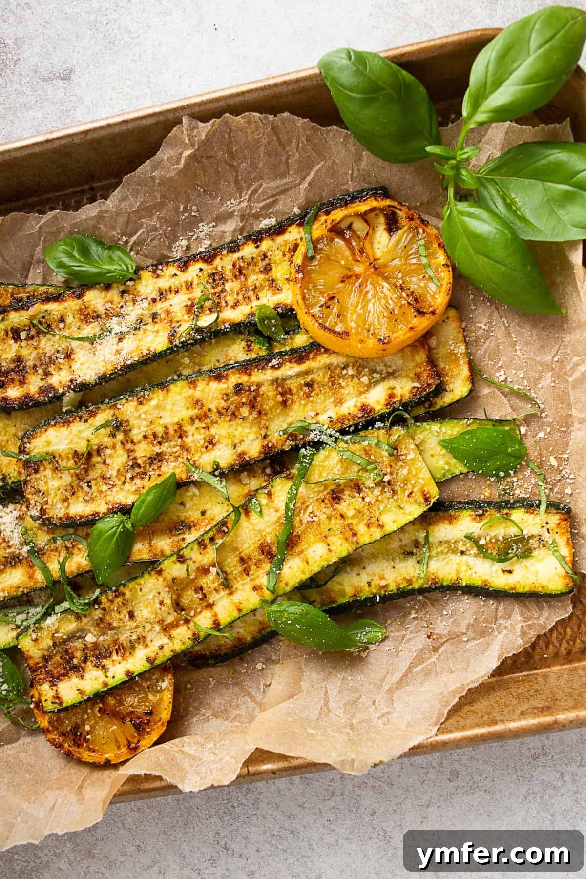 Fire-Kissed Zucchini 7 Grilled Zucchini topped with freshly grated Parmesan cheese and a sprig of fresh herbs.
