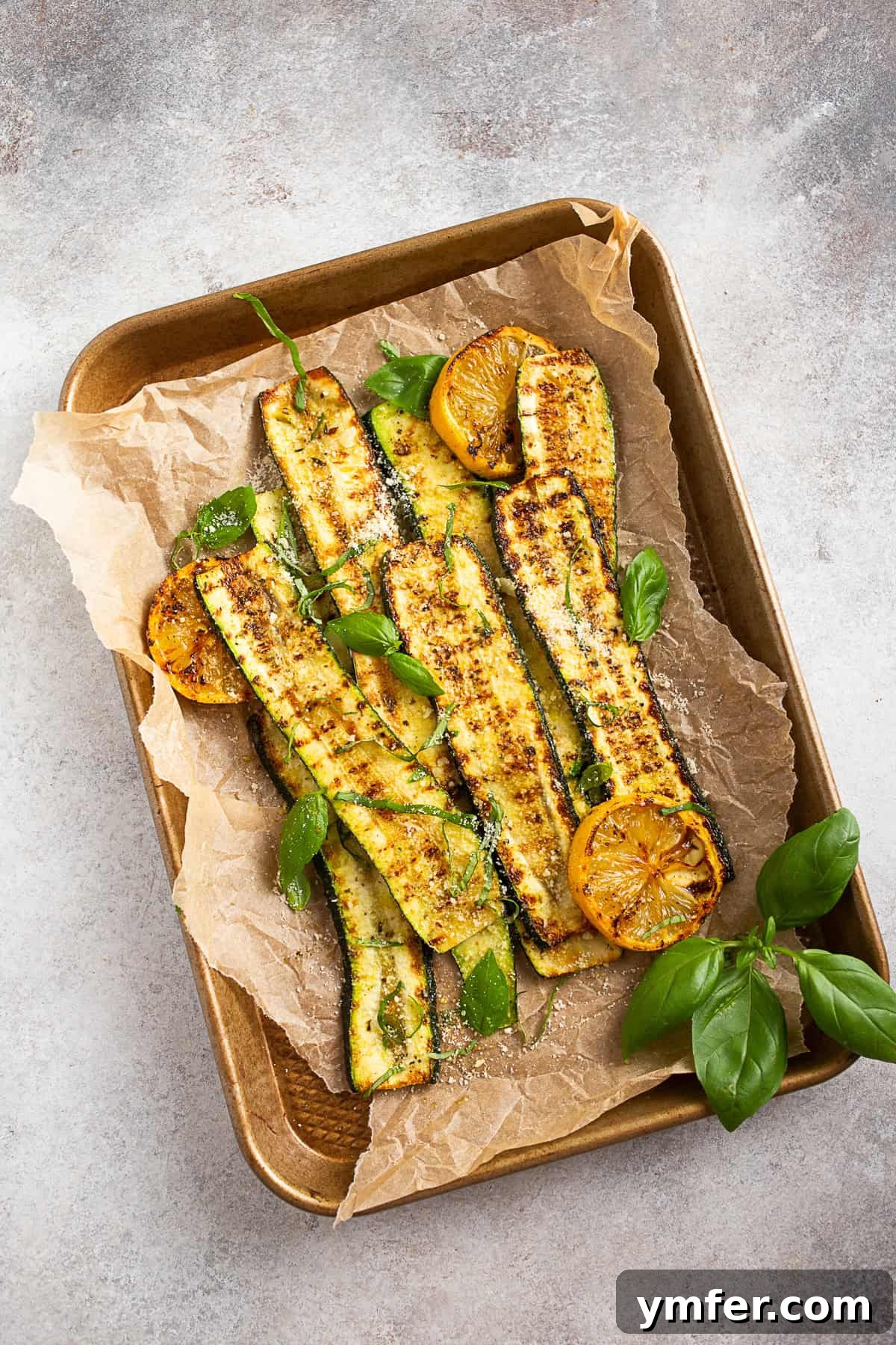 Fire-Kissed Zucchini 8 Grilled Zucchini arranged on a sheet with grilled lemon halves, ready to serve.