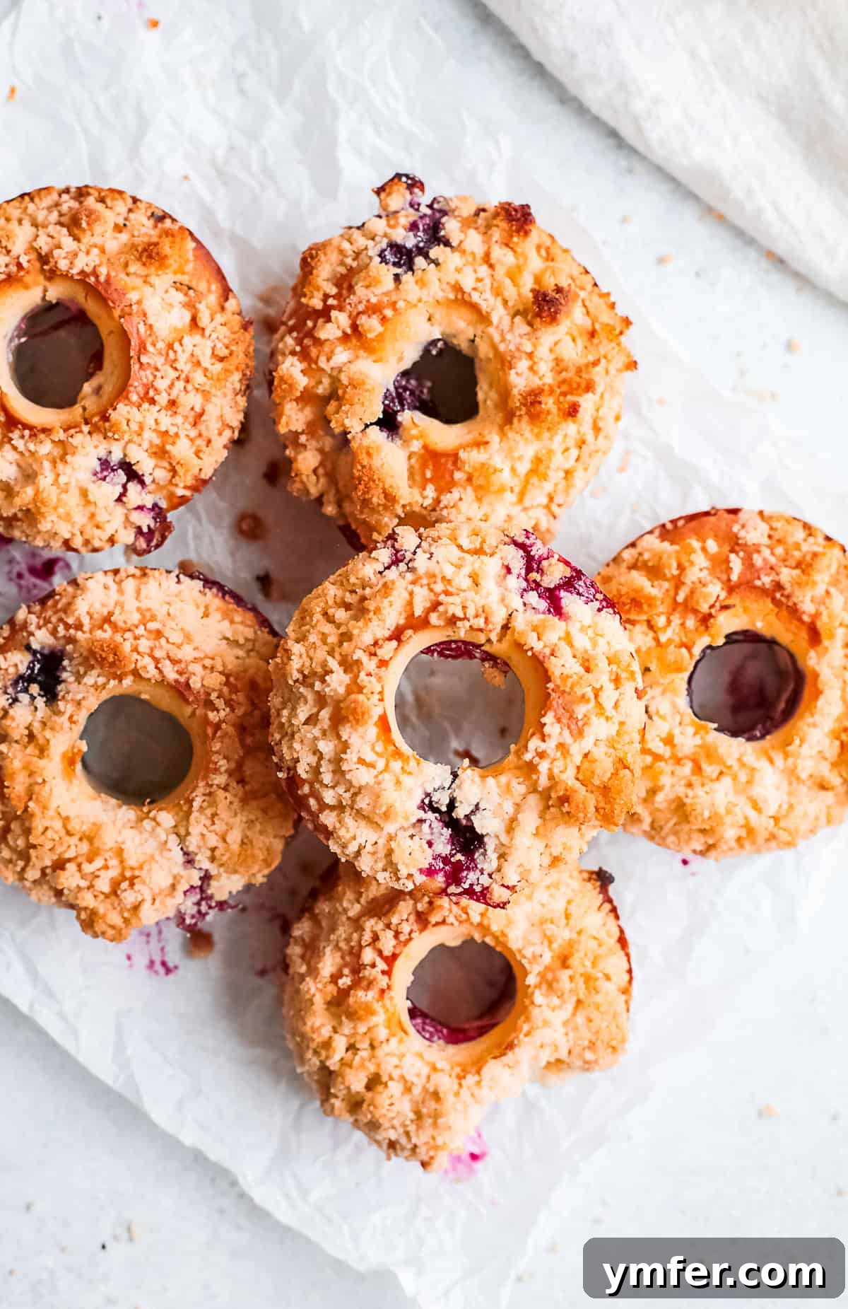 Baked Blueberry Streusel Donuts with a bite taken out of it, showcasing the fluffy texture and blueberries.