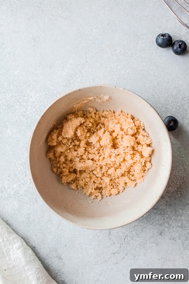 Crumbly streusel topping in a small bowl, ready to be added to donuts.